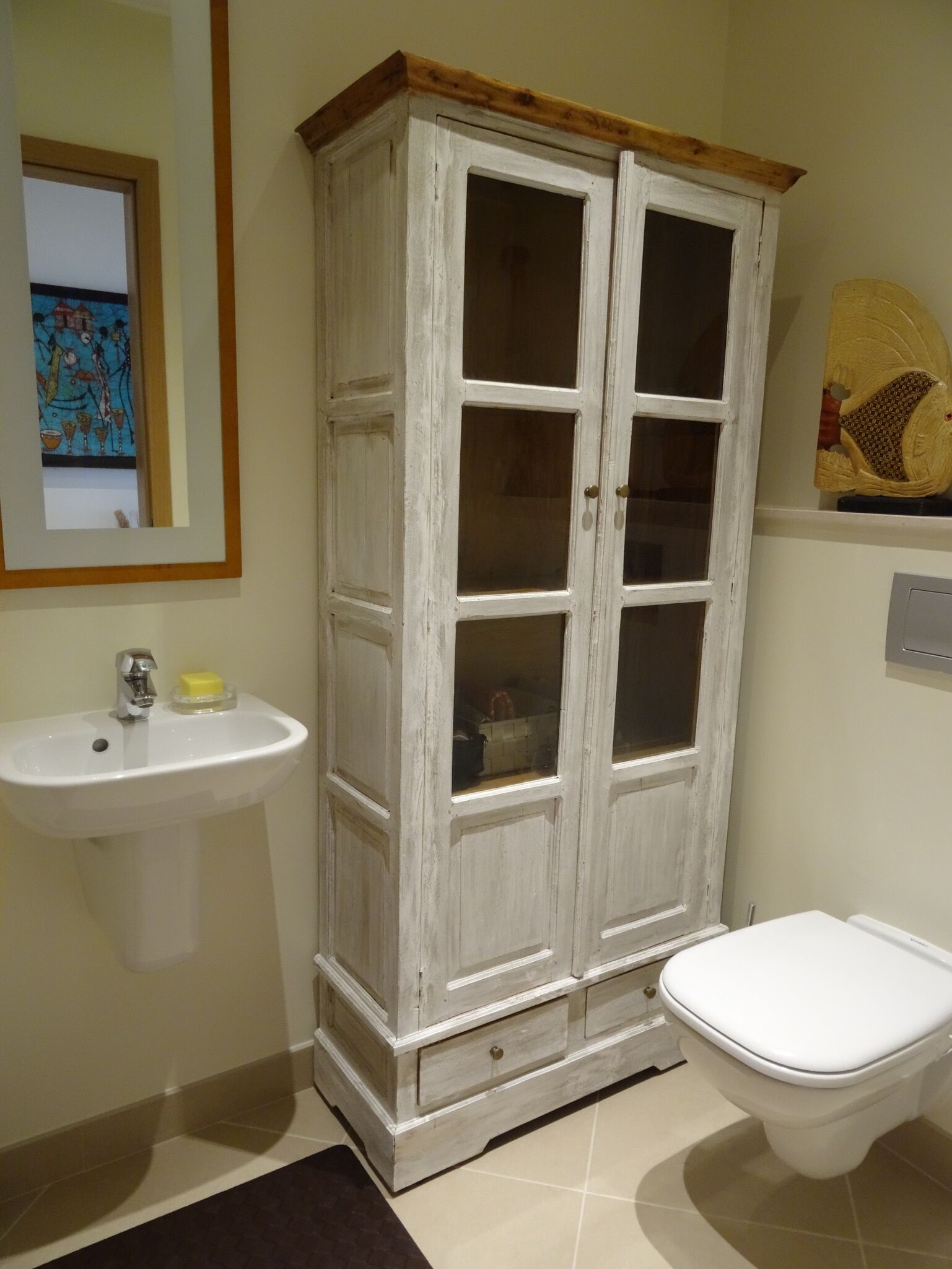 Un baño con un mueble blanco, un lavabo y un inodoro.
