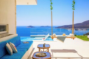 Un balcón con vistas al mar, un sofá, una mesita y una silla.
