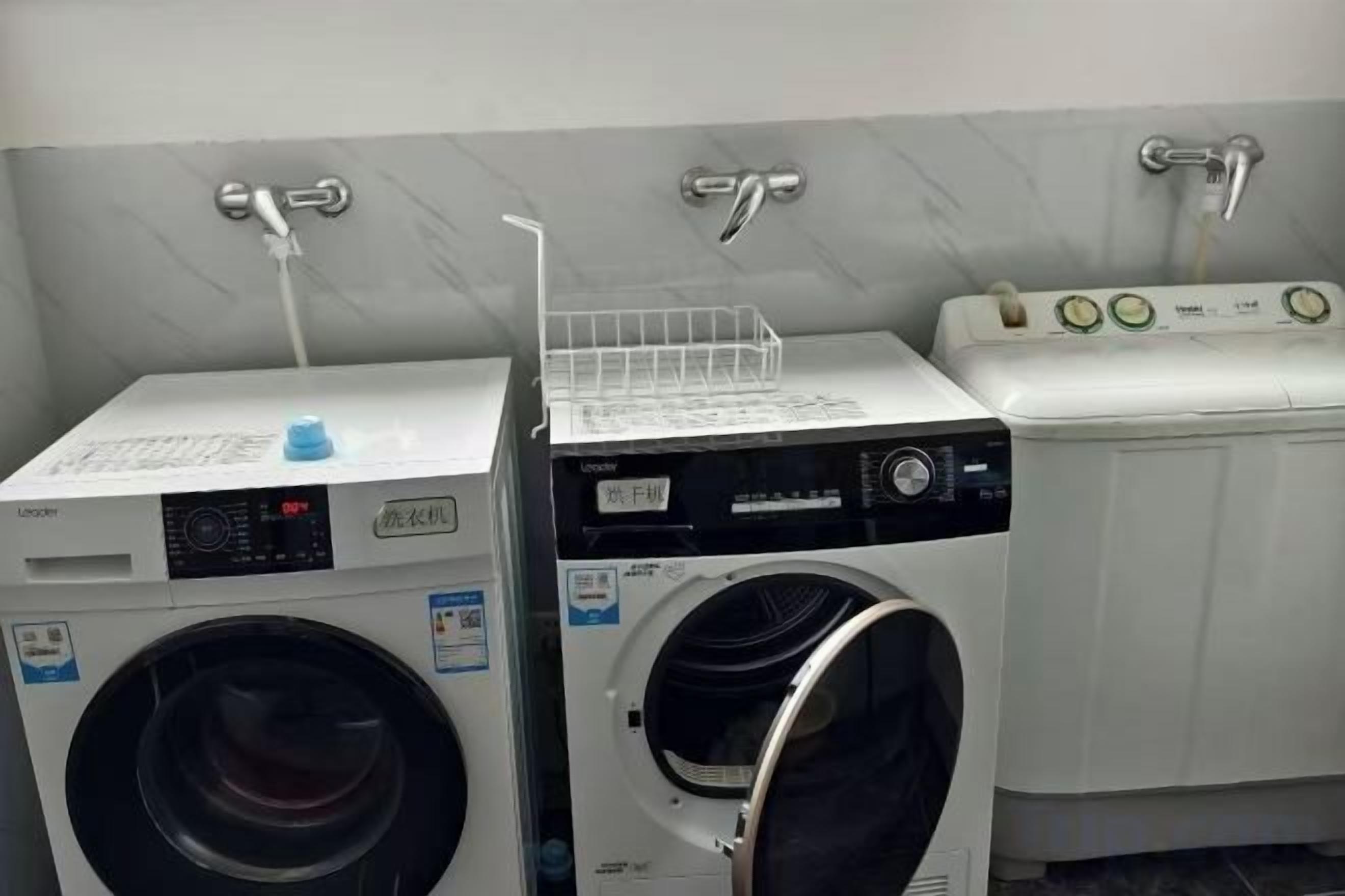 A laundry room with two washing machines and a dryer.
