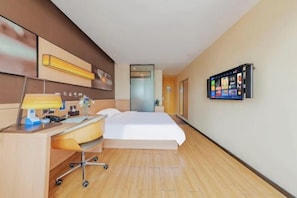 A hotel room with a bed, desk, chair, lamp, and a mounted TV. - Feihong Boutique Hotel (Guangzhou North Railway Station) (Guangzhou)