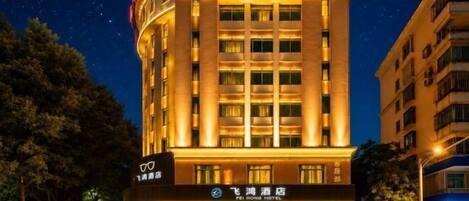 A hotel with a modern design, featuring a prominent entrance and multiple floors.