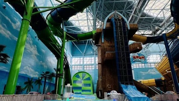 An indoor water park with slides, a large pool, and a tropical-themed mural. - Feihong Boutique Hotel (Guangzhou North Railway Station) (Guangzhou)