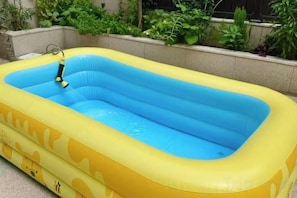 Una piscina inflable con interior azul, rodeada por un exterior amarillo con un diseño de oso.