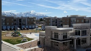 A modern apartment complex with a view of snow-capped mountains in the background. - Brand New Condo in Spanish Fork (Spanish Fork)