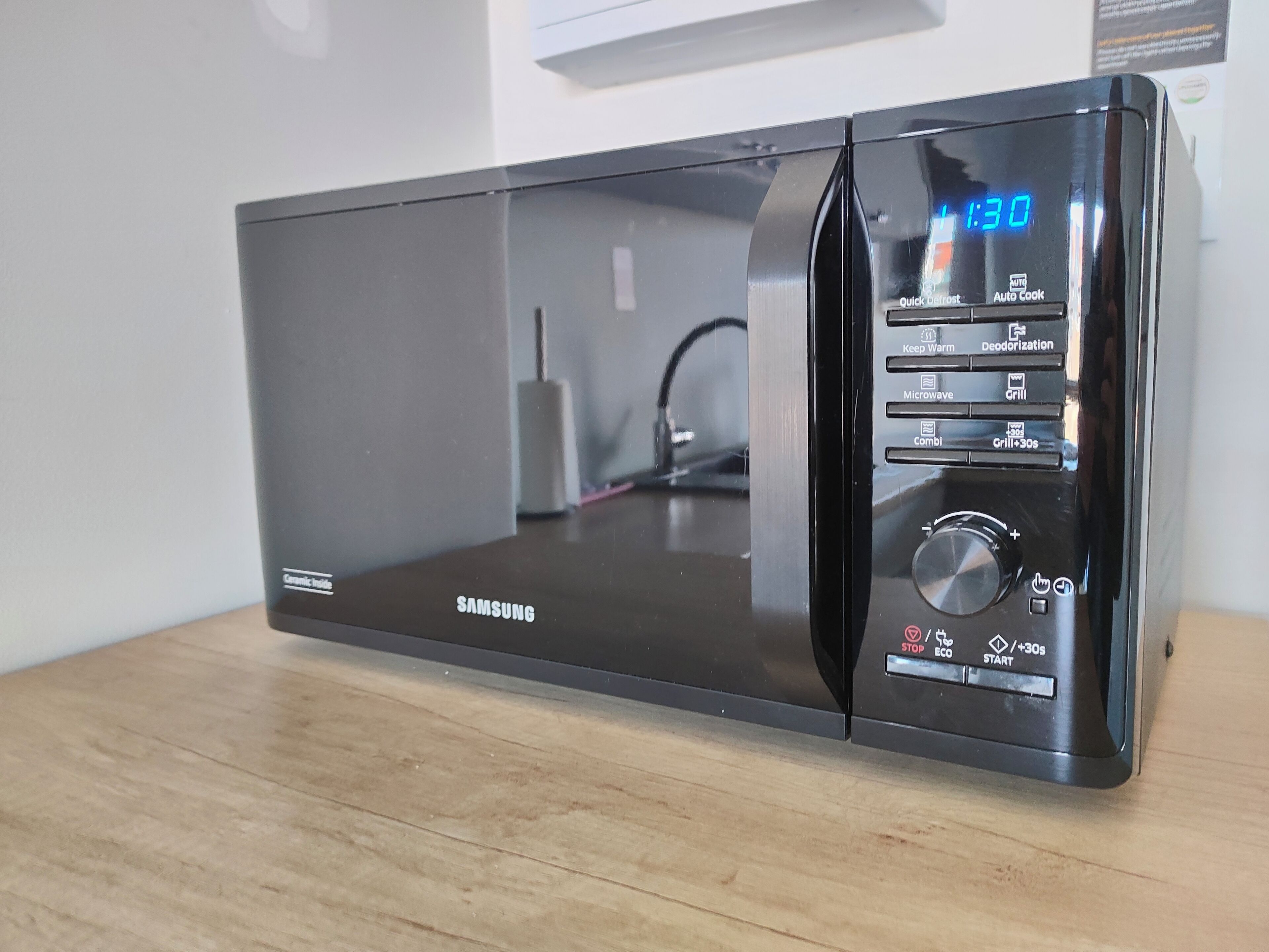 A black Samsung microwave with a digital display, a control panel with various settings, and a stainless steel finish.