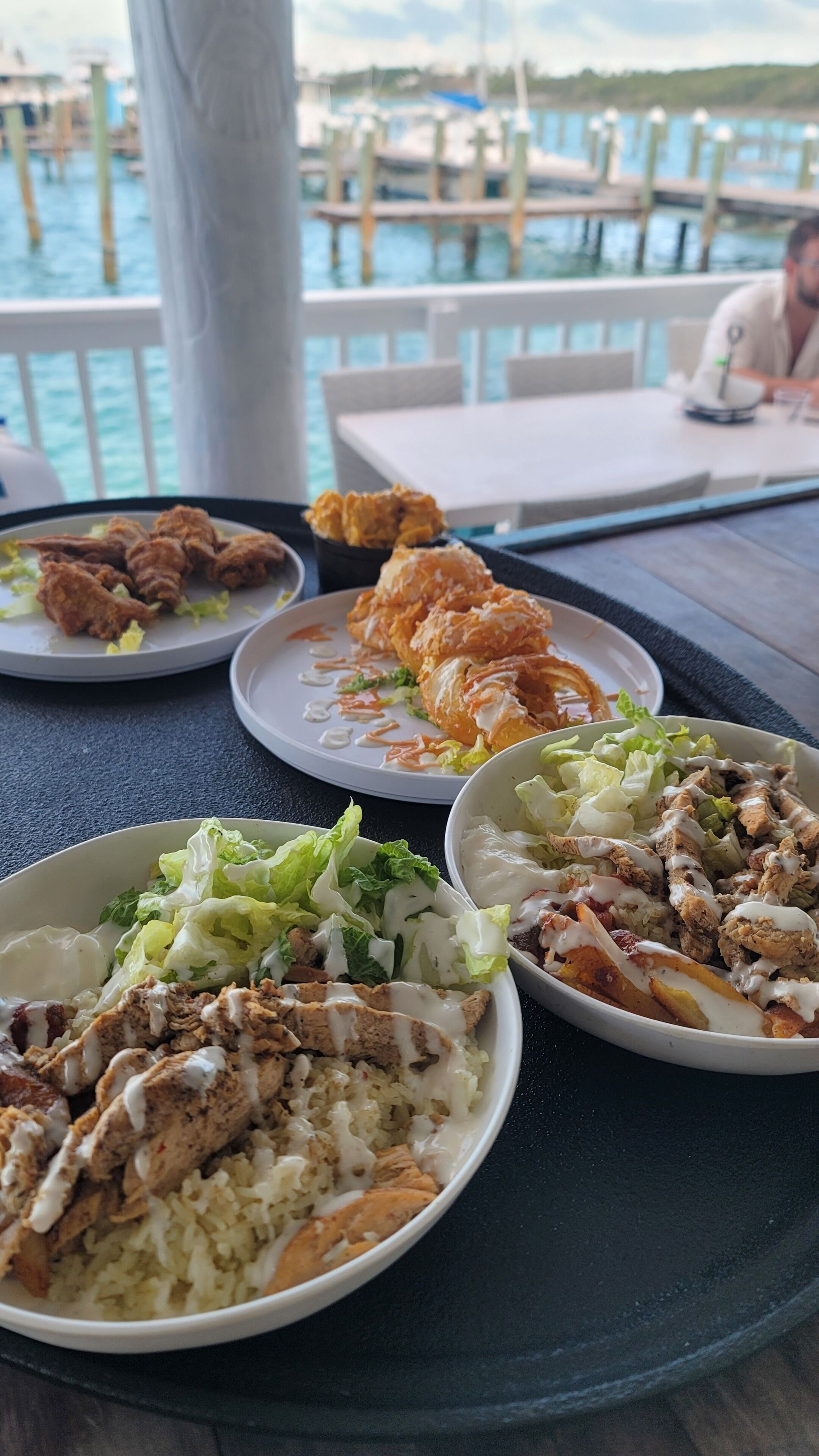 A dining table with various dishes including fried chicken, rice, and salads.