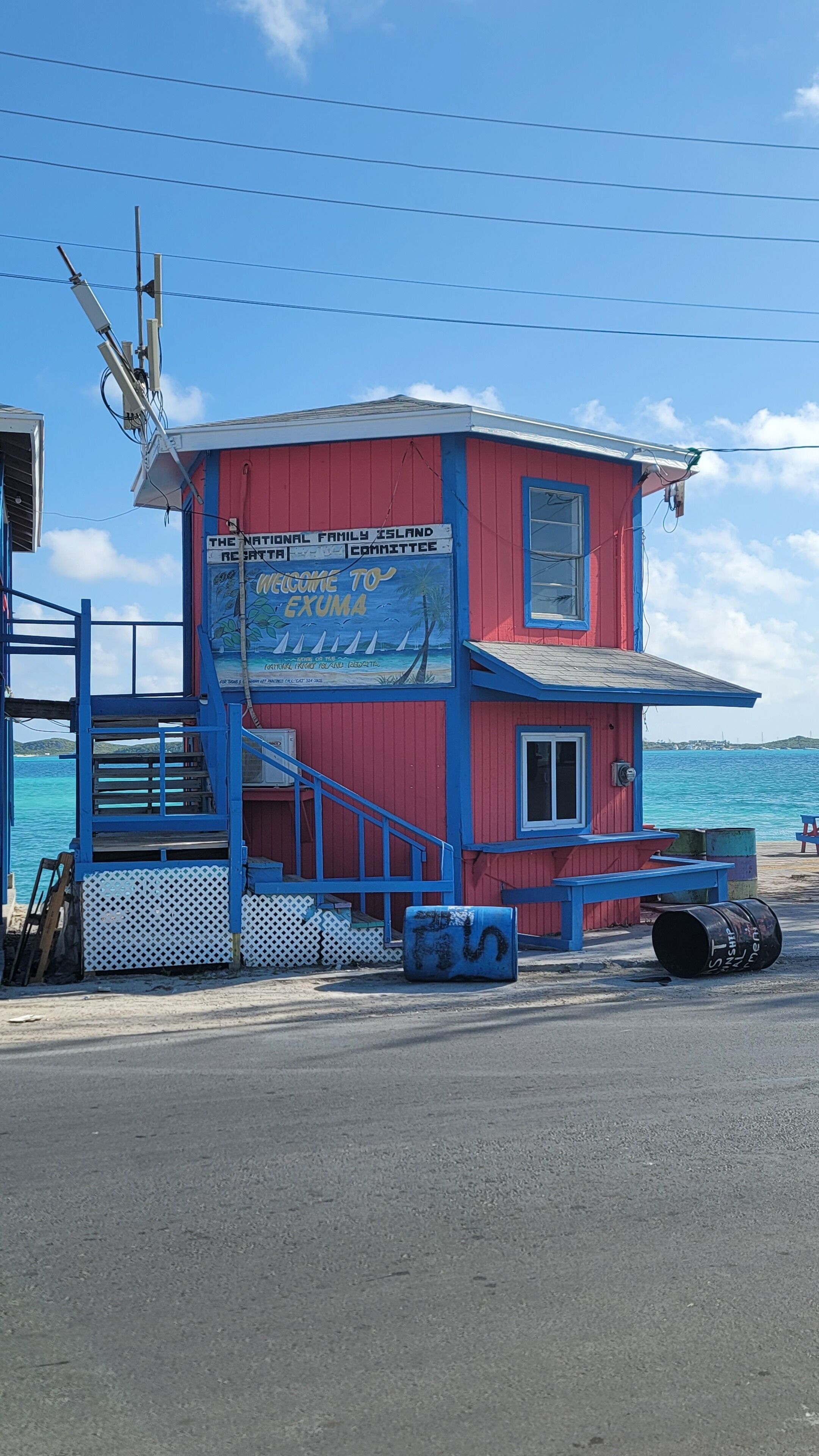 A red and blue lifeguard tower with a sign welcoming visitors to Exuma.