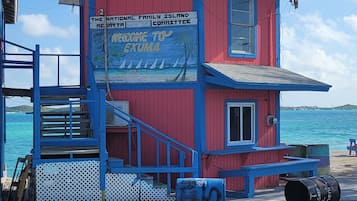A red and blue lifeguard tower with a sign welcoming visitors to Exuma.