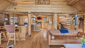 Ein Blockhaushaus-Interieur mit Essbereich, Küche und einer gemütlichen Sitzecke.