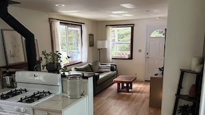A kitchen with a stove, a dining area with a table and chairs, a sofa, and a staircase leading to another level. - Cozy cottage in charming Trinidad with WiFi (Trinidad)