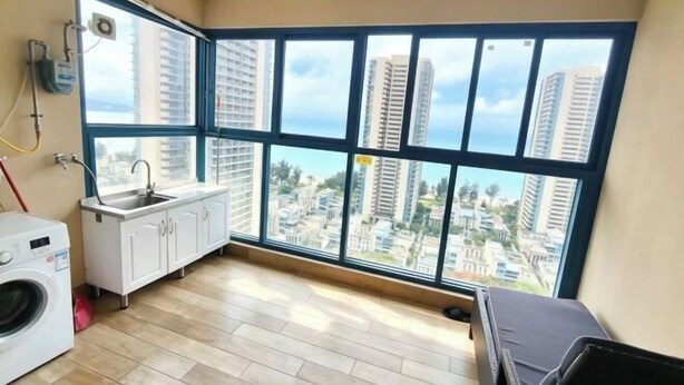 A room with a large window, a washing machine, a sink, and a cabinet. - Huidong Vanke Shuangyue Bay Xinyue Vacation Apartment (Huidong)