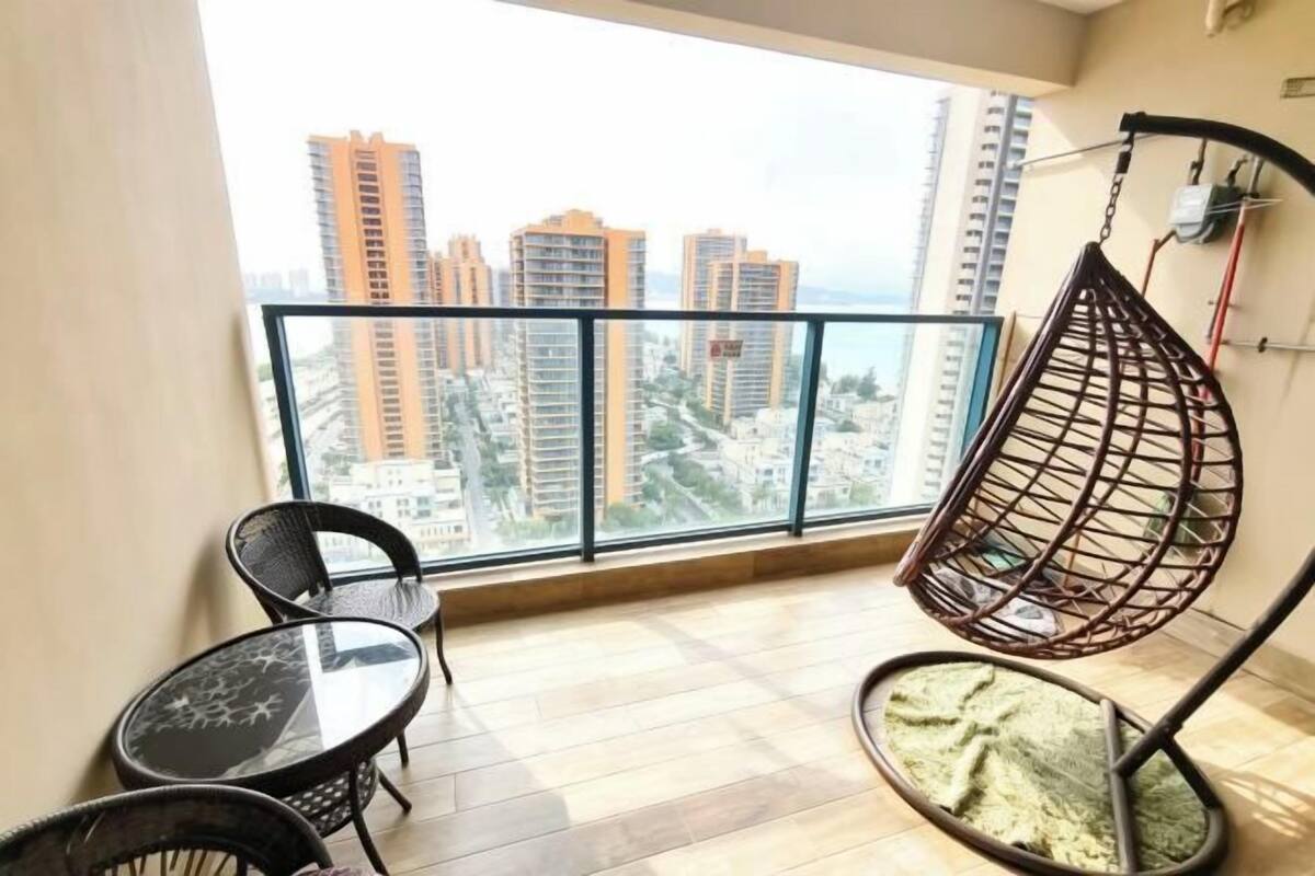 A balcony with a hanging chair, a small table, and chairs.
