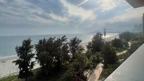 A coastal view with a beach, trees, and a clear sky. - Huidong Vanke Shuangyue Bay Xinyue Vacation Apartment (Huidong)