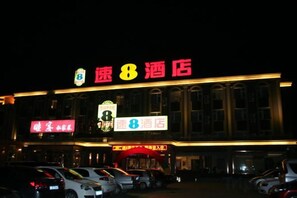 Hotel amb un cartell ben visible que diu 'Speed 8 Hotel' i diverses places d'aparcament al davant.