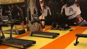 Un gimnasio con cintas de correr, bicicletas estáticas y máquinas de pesas.