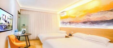 A hotel room with two beds, a TV, a small table with a chair, and a painting of a sunset on the wall.