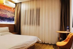 A hotel room with a bed, a small table, a chair, and a painting on the wall. - Orange Hotel (Taiyuan Qinxian North Street Maoye Tiandi Branch) (Taiyuan)