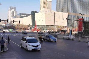 A busy urban intersection with a large commercial building in the background. - Orange Hotel (Taiyuan Qinxian North Street Maoye Tiandi Branch) (Taiyuan)