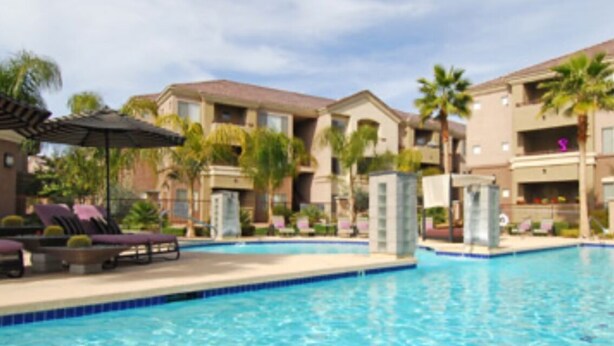 A swimming pool with lounge chairs and palm trees. - Chic 1-bedroom apartment in fabulous Phoenix with beautiful pool and BBQs (Phoenix)