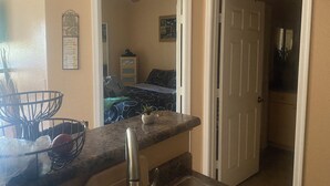 A kitchen with a granite countertop, a sink, and a cabinet. There is a door leading to another room. - Chic 1-bedroom apartment in fabulous Phoenix with beautiful pool and BBQs (Phoenix)