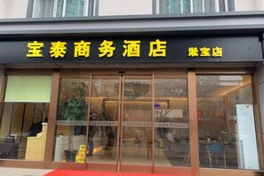 A hotel with a black awning and yellow signage.