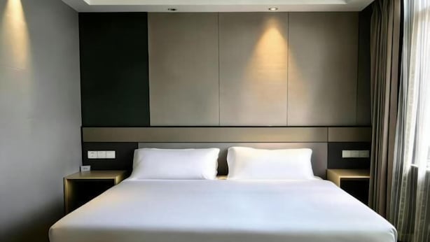 A modern hotel room with a large bed, two bedside tables, and a neutral color palette. - Baotai Business Hotel (Shanghai Wusong International Cruise Terminal Songbin Road Subway Station) (Shanghai)