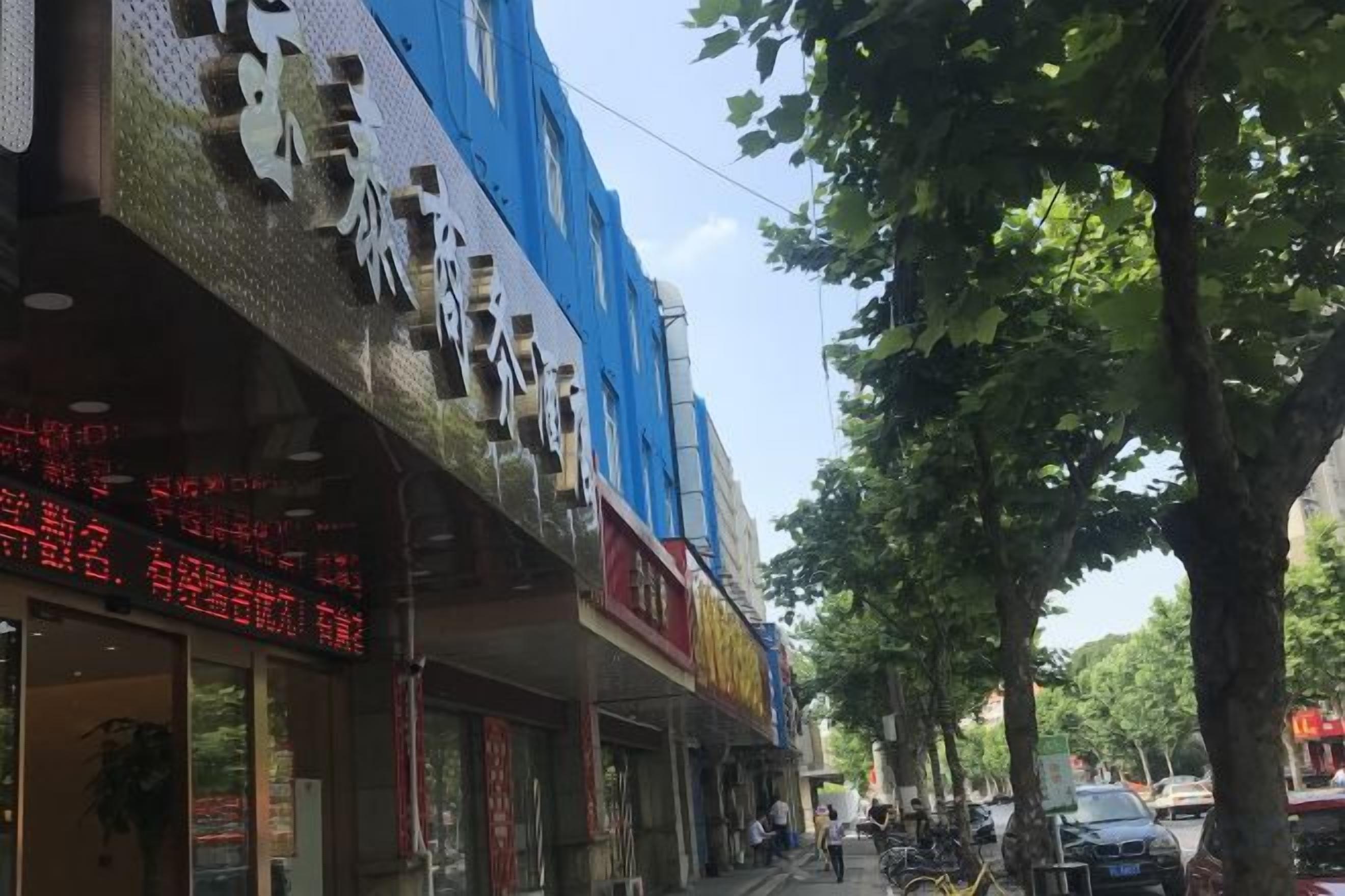 Une rue bordée de boutiques et d’arbres.