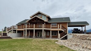 A two-story house with a balcony, a covered porch, and a driveway.