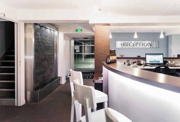 A reception area with a reception desk, a computer, and a sign that reads "RECEPTION". - L'auberge (Kinshasa)