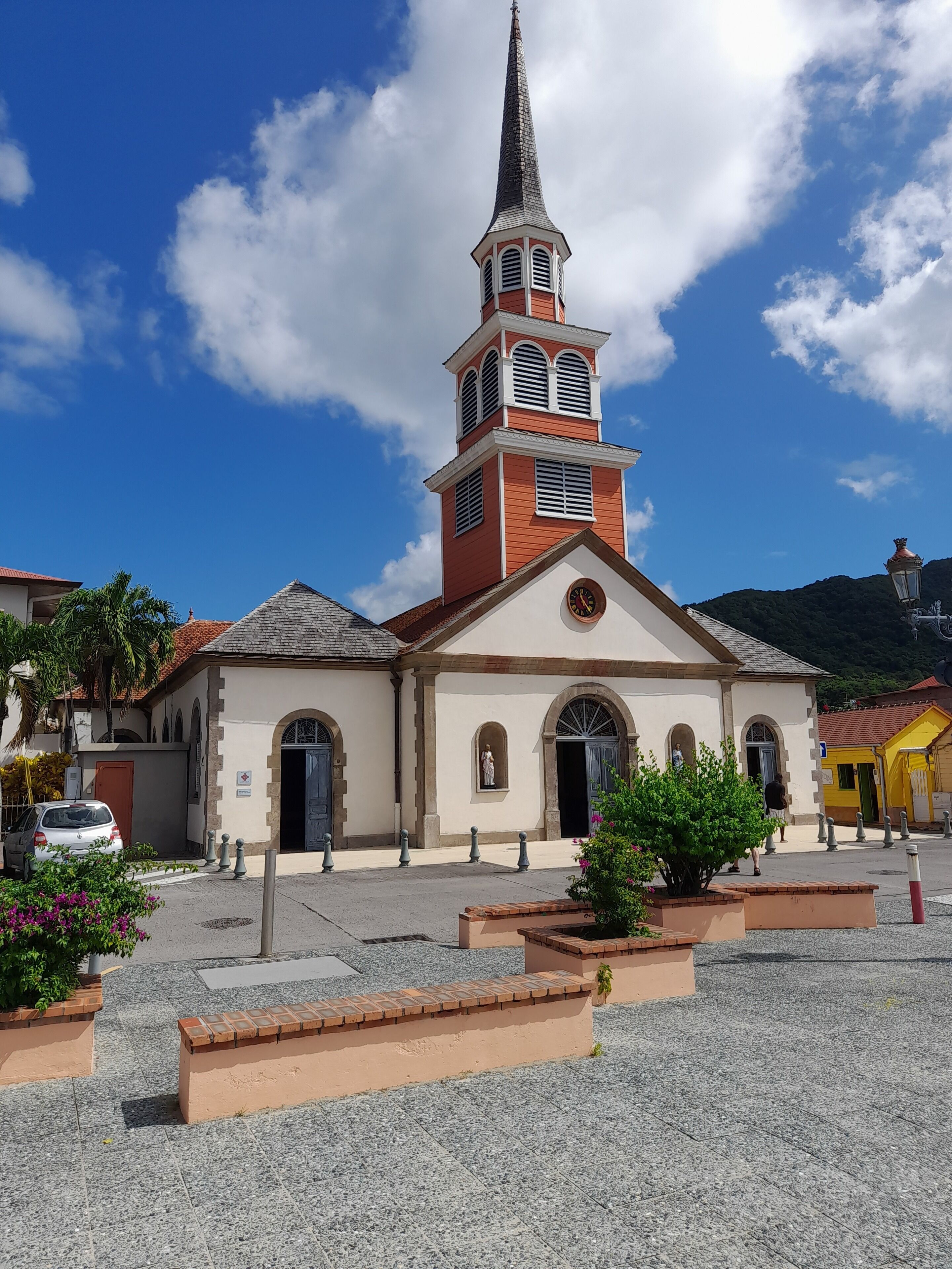 Eine Kirche mit einem hohen Turm, Rundbogenfenstern und einer Uhr.