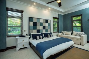 A bedroom with a bed, bedside tables, a nightstand, a sofa, and a ceiling fan. - Bella Vista 7E, 3Bdr/3.5 Bth Condo (Playa Herradura)