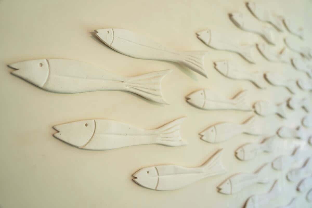 Une rangée d’objets en forme de poisson est fixée au mur.