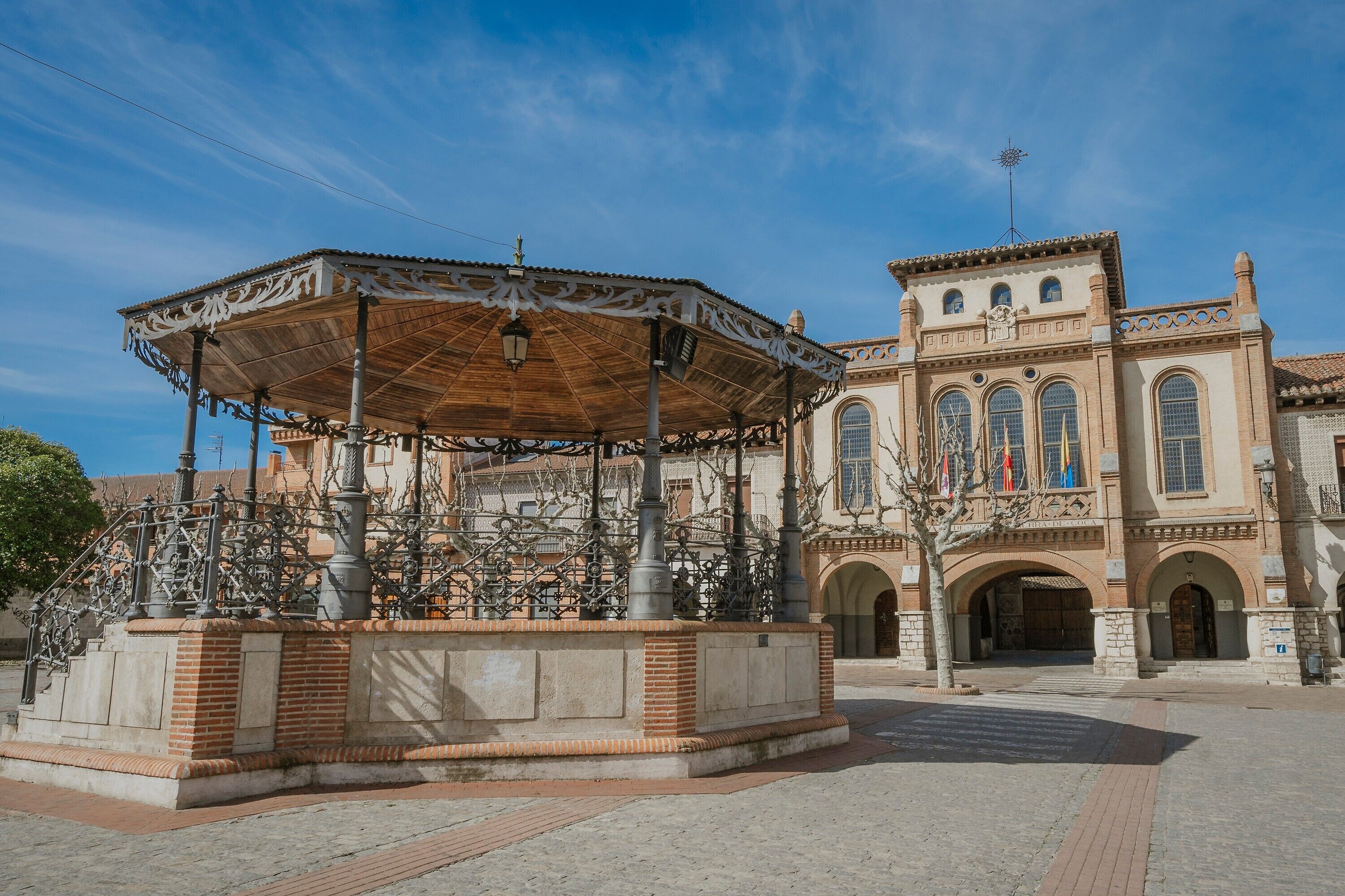 Un bâtiment historique doté d’une cour intérieure, d’une grille en fer forgé ouvragée et d’un belvédère décoratif.