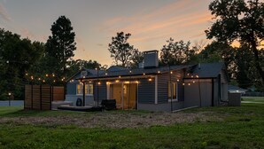 Una casa amb un porxo, mobiliari exterior i llums de garlandes.