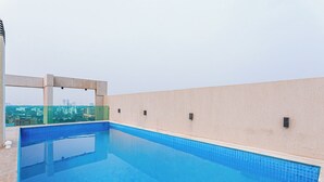 A rooftop swimming pool with a clear view of the city skyline in the background. - Sky Stays at Agora Villamorra (Asunción)