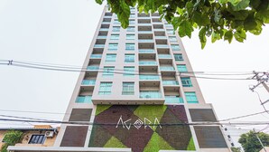 A tall building with a distinctive geometric pattern on its facade and the name "ACORA" prominently displayed. - Sky Stays at Agora Villamorra (Asunción)