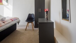 A bedroom with a bed, a desk, a chair, and a wardrobe. - WoodHus Lodge  Large Double Room 3 (Stoke-on-Trent)
