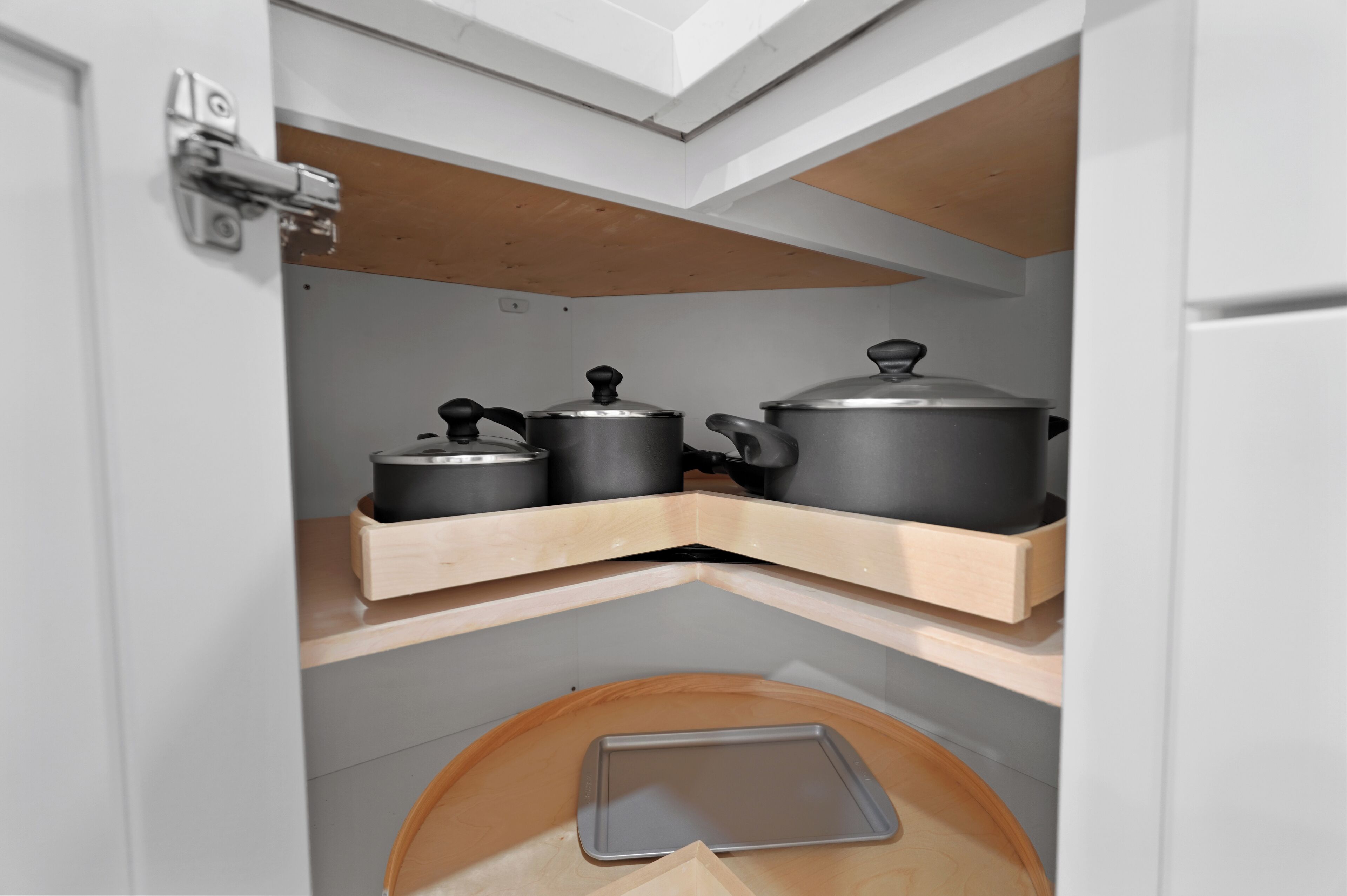 Een keuken met houten planken met er op pannen en een dienblad.