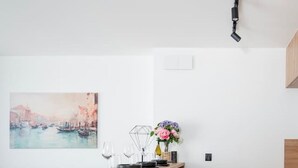 Una cocina moderna con una isla de madera, taburetes negros y una mesa de comedor.