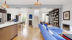 Un espacio habitable moderno con cocina, comedor y un amplio sofá azul.