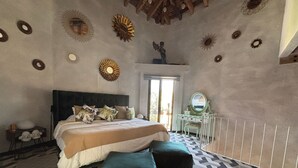 Une chambre à coucher avec un grand lit, une commode et une statue d’ange décorative au plafond.