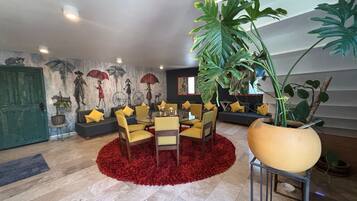 A modern living room with a round table, yellow chairs, and a red shag rug.