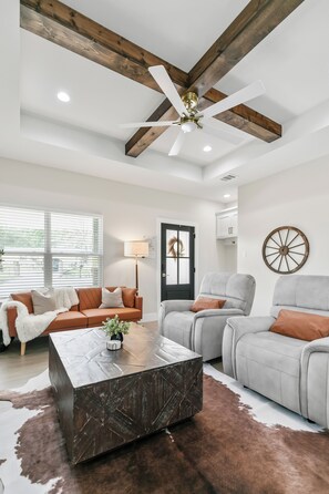 Relax in this stylish living room with a large coffee table, two armchairs, and a sofa.