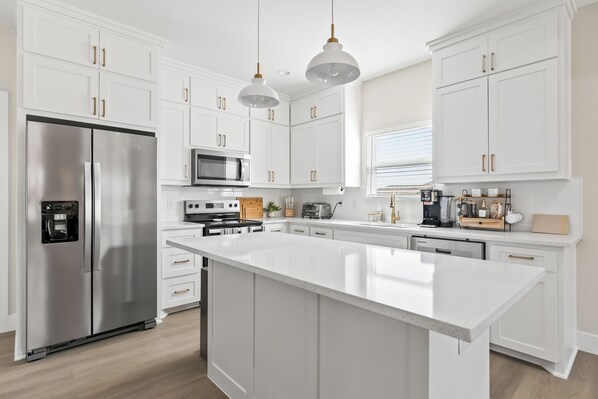 Enjoy cooking in this well-equipped kitchen with a central island, oven, and stainless steel appliances.
