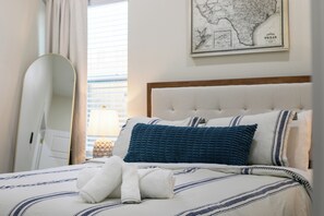 Relax in comfort with a large bed, a full-length mirror, and a framed map of Texas.