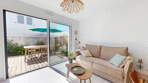 A modern living room with a sliding glass door leading to a patio area.