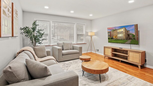 A modern living room with a sofa, a coffee table, a TV, and a plant.