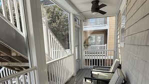 A covered porch with a ceiling fan, white railings, and two chairs. - Your Perfect Beach Getaway!  Gorgeous and spacious home perfect for a group! (Virginia Beach)