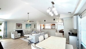A spacious living room with a fireplace, a dining area, and a kitchen in the background. - Your Perfect Beach Getaway!  Gorgeous and spacious home perfect for a group! (Virginia Beach)