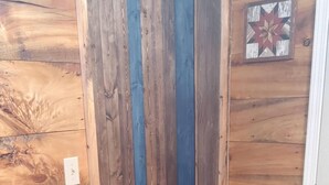 Un interior de madera con un panel vertical azul, una puerta blanca y una decoración en forma de estrella en la pared.